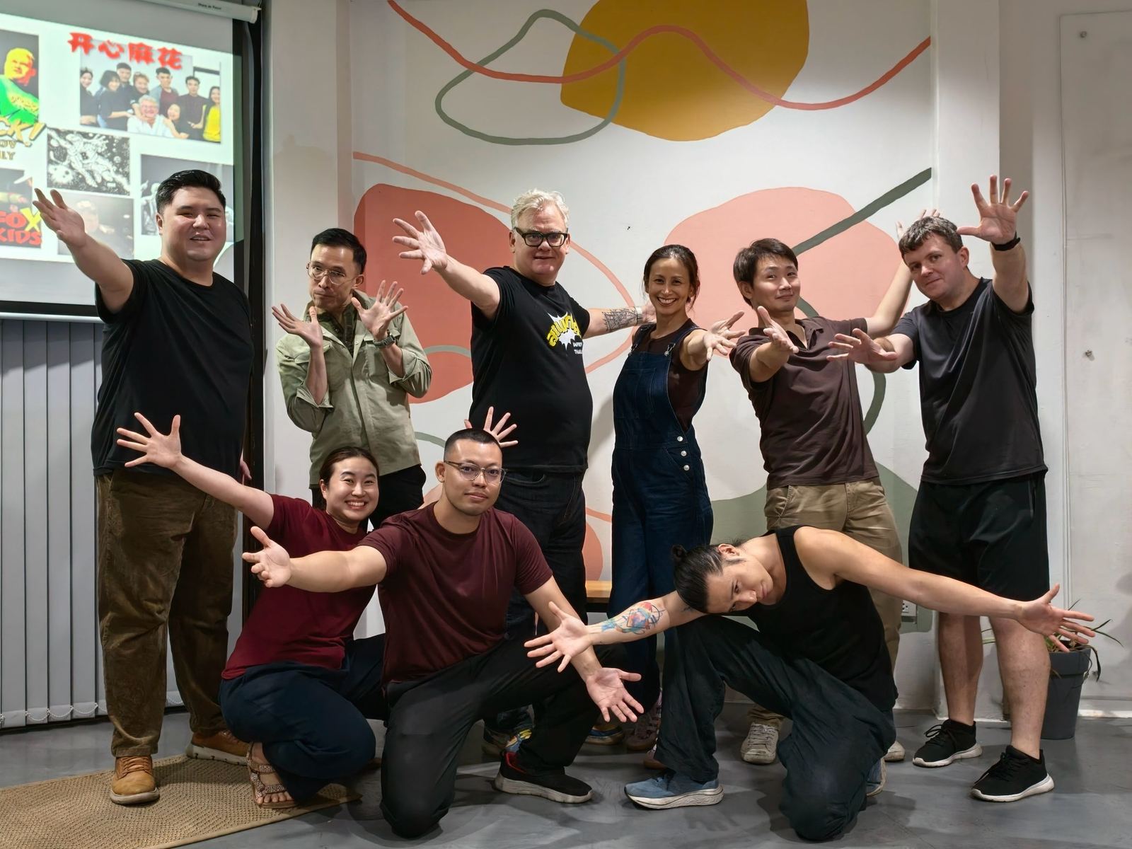 A group of Improv for Everyone participants and Curt posing together with big gestures