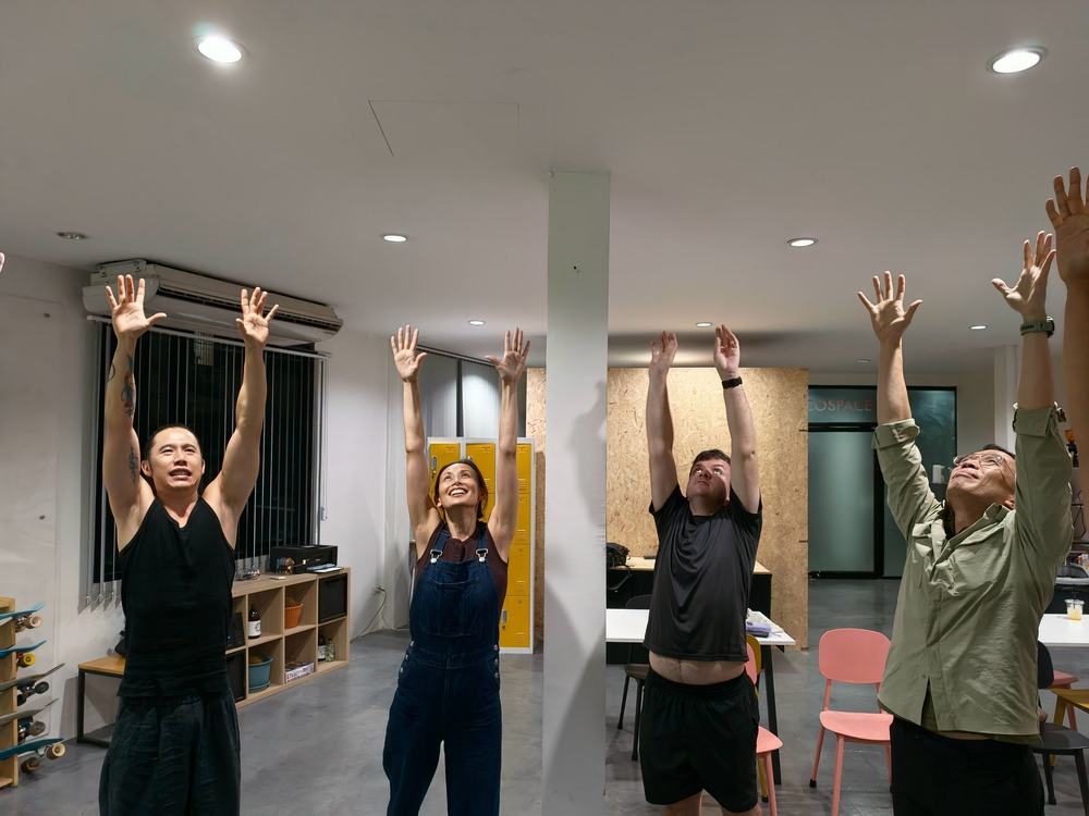 Participants stretching their arms up in a warm-up